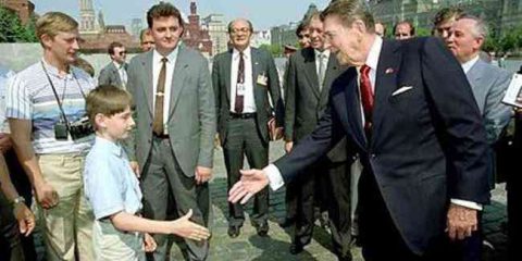 Chi è costui? Il primo a sinistra con la fotocamera al collo…un giovane Vladimir Putin durante la visita di Ronald Reagan