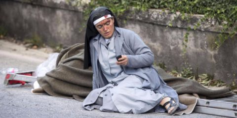 Una delle foto simbolo del terremoto: Suor Mariana, la monaca albanese vicino ad una vittima del terremoto, che manda un sms